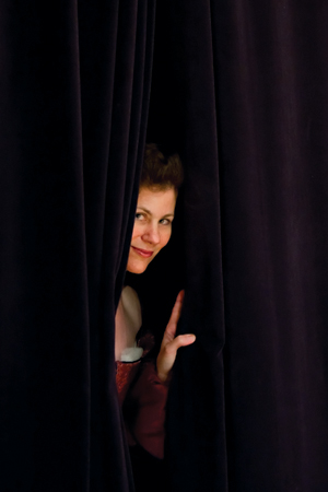 Dr. Marguerite Tassi peaking through curtain