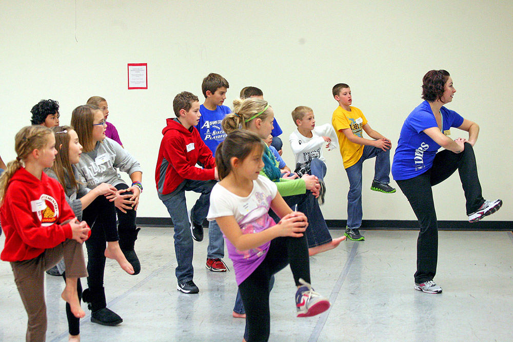 UNK music and performing arts lecturer Dayna DeFilippis, right, gives a dance lesson to fifth- and sixth-grade students during the recent Region IV Youth Leadership Conference. Hosted by the UNK College of Education, the event aims to build leadership skills and reward area students for leadership roles they have taken in their schools. (Photo by Sara Giboney/UNK News)