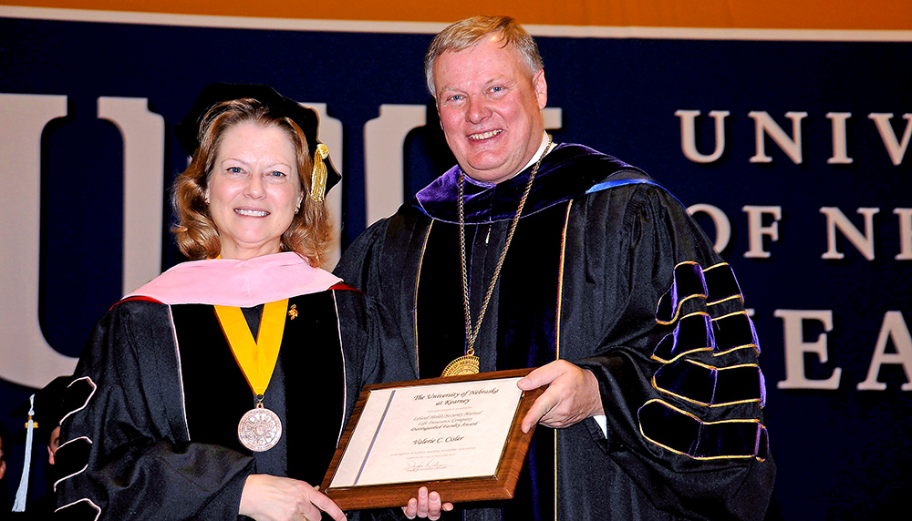 Valerie Cisler, chair of the Department of Music and Performing Arts, receives the Leland Holdt/Security Mutual Life Distinguished Faculty Award from University of Nebraska at Kearney Chancellor Doug Kristensen. (Photo courtesy of Grad Images)