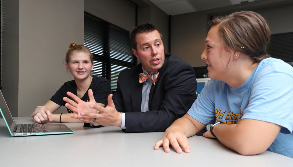Ben Malczyk, assistant professor of social work, discusses UNK’s new online social work programs with students Kenna Storrs of Kearney, left, and Hannah Brown of Scottsbluff. (Photo by Corbey R. Dorsey, UNK Communications)