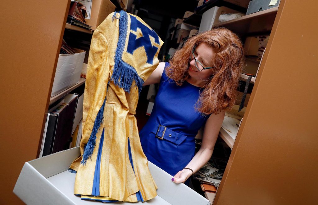 Laurinda Weisse pulls out an old cheer squad outfit preserved in the UNK archives. Weisse has been the UNK archivist since October 2014. (Photo by Corbey R. Dorsey, UNK Communication