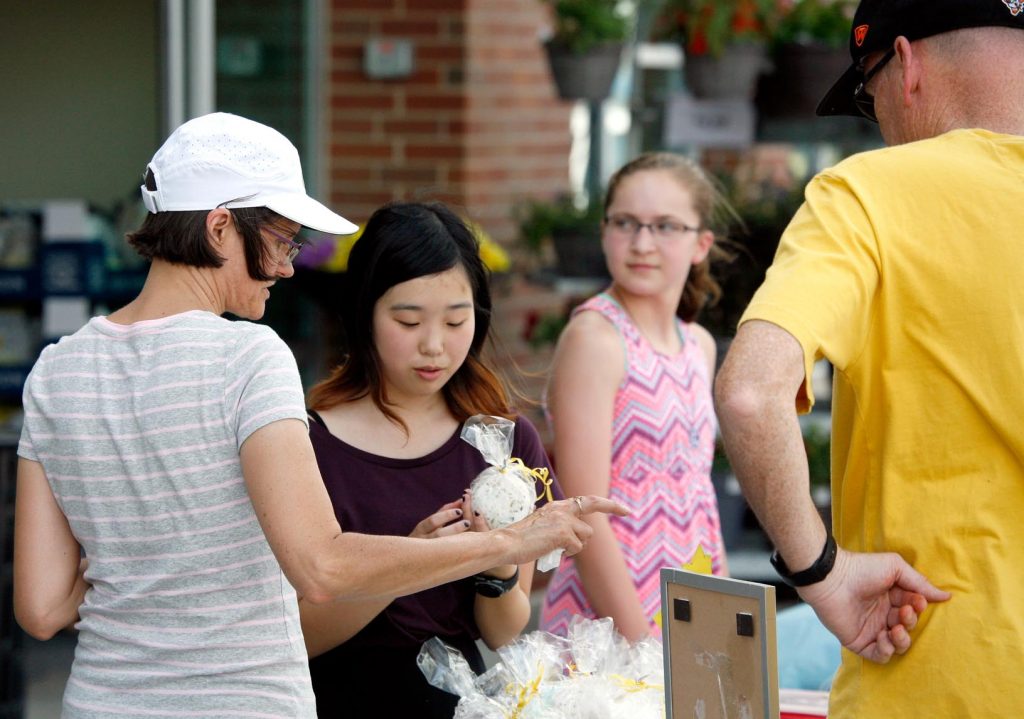 Thirteen-year-old Isabella Cao of Kearney, second from left, talks to customers about her handmade bath products Friday evening during the Biz Kidz Camp product showcase at the Kearney Hy-Vee. (Photo by Tyler Ellyson, UNK Communications)