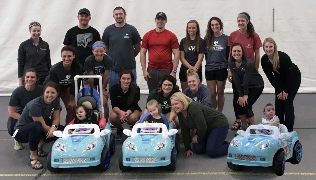 Students in the University of Nebraska Medical Center’s Physical Therapy Education program in Kearney, along with engineering students at the University of Nebraska at Kearney, meet with the children and three cars the students modified.