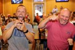 Bryce Abbey, left, and friend Brian Hagan celebrate Friday as they watch a scene from the show “TKO: Total Knock Out” at a watch party in Kearney. Abbey, a professor at University of Nebraska at Kearney, won the episode and $50,000. (Photo by Todd Gottula, UNK Communications)
