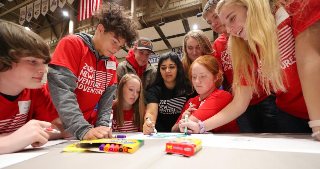 UNK student Tanya Wasson of Kearney, center, works with a team of high schoolers Thursday during New Venture Adventure at UNK. The event, hosted by the Enactus student organization, promotes entrepreneurship. (Photo by Corbey R. Dorsey, UNK Communications)