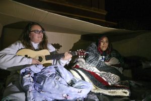 UNK students, from left to right, Sadie Brandt, Carrie Hardage and Jayme Gomez, all of Kearney, slept outside in cardboard boxes Friday as part of Chi Sigma Iota’s “A Night Without a Home,” which raises awareness about homelessness. (Photo by Corbey R. Dorsey, UNK Communications)