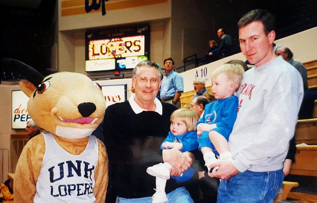 A very young Morgan and Trevor Daubert attend a UNK basketball game in 2001 with their father Mike, right, grandfather Les Livingston and a very old Louie the Loper mascot. (Courtesy photo)