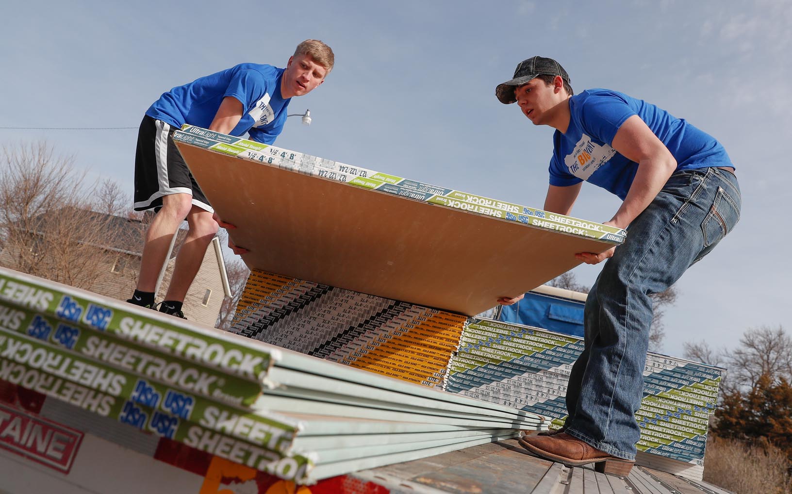 UNK students Zach Ciborn of Columbus, left, and Riley Mrkvicka of Farwell load Sheetrock off a semitrailer Saturday while helping with flood recovery efforts in Gibbon. They joined 500 other University of Nebraska at Kearney students who volunteered in Kearney and area communities as part of UNK’s The Big Event. (Photo by Corbey R. Dorsey, UNK Communications)