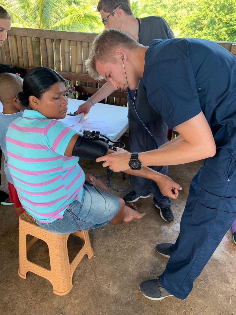 UNK student Trevor Daubert checks a patient’s vital signs at a mobile medical clinic in Panama. Twenty-one members of the UNK chapter of Volunteers Around the World traveled to the Central American country last month to work in mobile medical clinics that provided free care and medication to more than 300 patients. (Courtesy photo)