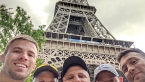 From left, UNK head wrestling coach Dalton Jensen, UNK assistant coach Tom McCann, Loras College assistant coach Trevor Kittleson, UNK alumnus Kurt Karjalainen and UNK assistant coach Andrew Sorenson snap a selfie with the Eiffel Tower in the background while visiting Paris, France, during last month’s international trip. (Courtesy photo)