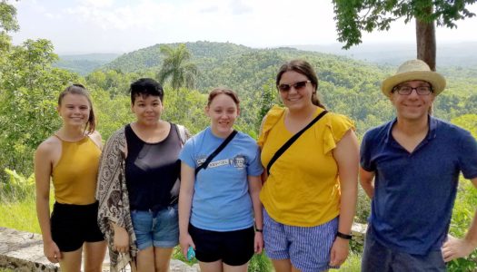 From left, UNK students Chloe Barkow, Cheily Arreola, Mia Grant and Alexis Chapelle pose for a photo with political science professor William Aviles during last month’s trip to Cuba. The group is pictured at Las Terrazas, a UNESCO biosphere reserve in the Sierra del Rosario mountains. (Courtesy photo)