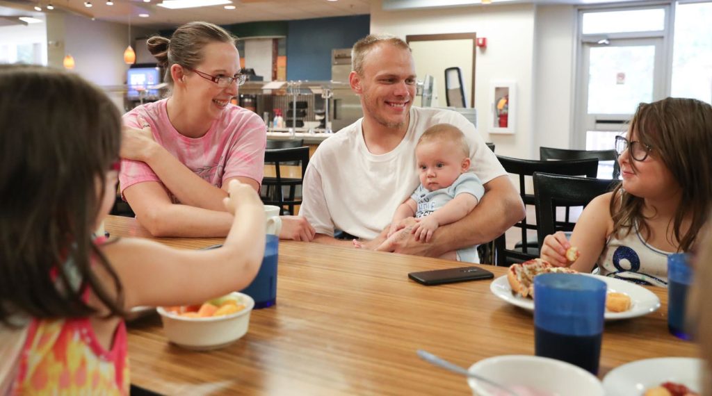 Danielle and Skyler Barker of Gibbon and their children, clockwise from left, Faith, Mateo and Ellen eat lunch Friday at The Market @ 27th inside UNK’s Nebraskan Student Union after their home was flooded. Sodexo, UNK’s dining services provider, served about 1,400 meals to people displaced by last week’s flooding. (Photo by Corbey R. Dorsey, UNK Communications)
