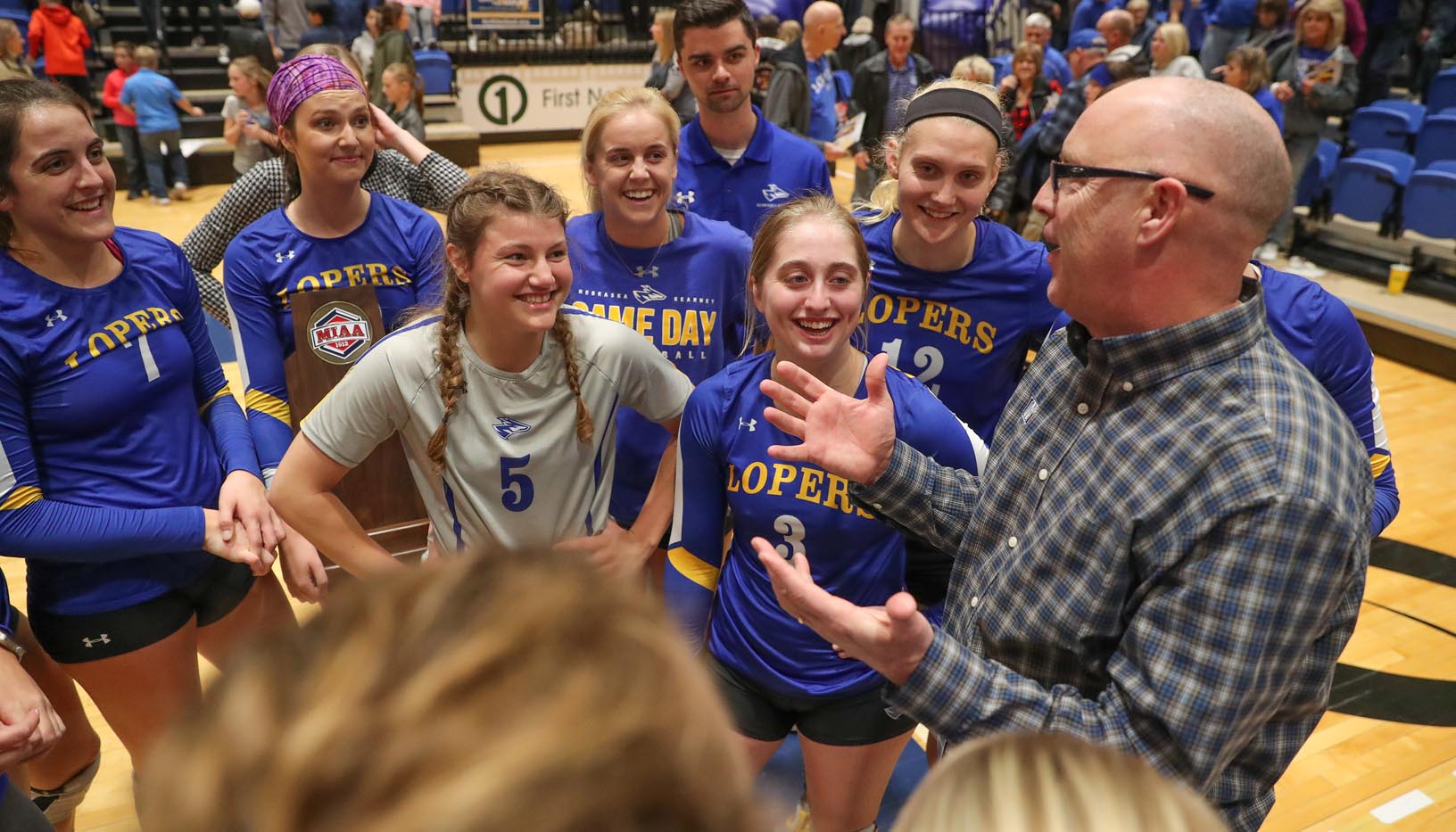 Inside UNK’s Health and Sports Center, Rick Squiers focuses on his role as head coach of the Loper volleyball team, which includes his daughters Anna, left, and Maddie, back middle. Away from campus, he switches to dad mode. (Photo by Corbey R. Dorsey, UNK Communications)