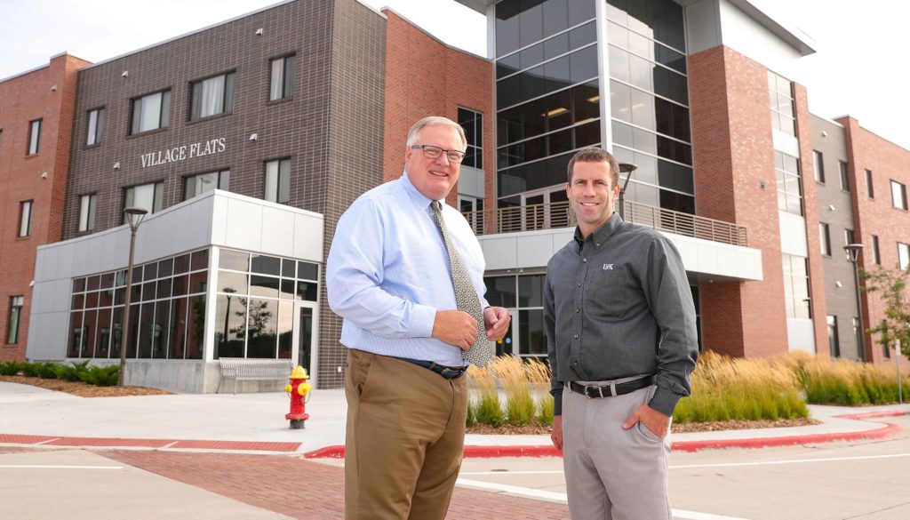UNK Chancellor Doug Kristensen, left, and Vice Chancellor for Business and Finance Jon Watts are pictured in front of the Village Flats housing complex in UNK’s University Village, a mixed-use development that will feature educational, residential, recreational, commercial and community engagement spaces. (Photo by Corbey R. Dorsey, UNK Communications)