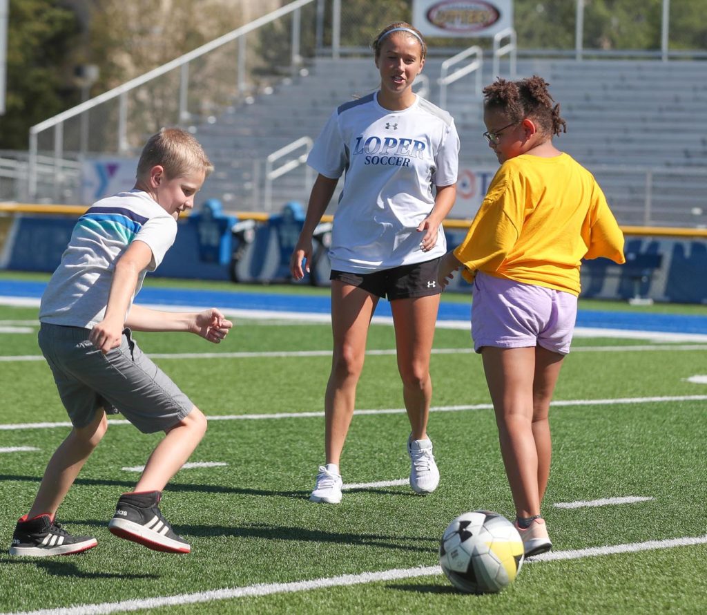 UNK soccer player Kylee Moore works with children at an activity at Cope Stadium during Early Awareness Day. Monday’s event brought 73 area fourth graders to UNK to learn more about the university, explore potential careers and have a little fun. (Photo by Corbey R. Dorsey, UNK Communications)