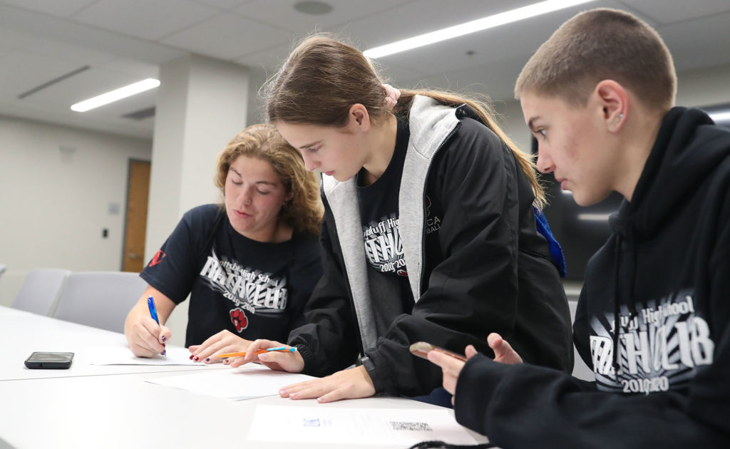 From left, Scottsbluff High School students Talera Kinsey, Katherine Reisig and Leah Polk solve a math problem Friday during a scavenger hunt at UNK.