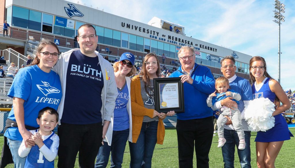 UNK Chancellor Doug Kristensen presents the Outstanding Family Award to Bill and Becky Williams of Kearney. Krista, far right, and Morganne, fifth from left, are current UNK students. Their oldest son Trevor and his wife Carly, far left, both graduated from UNK. (Photo by Corbey R. Dorsey, UNK Communications)