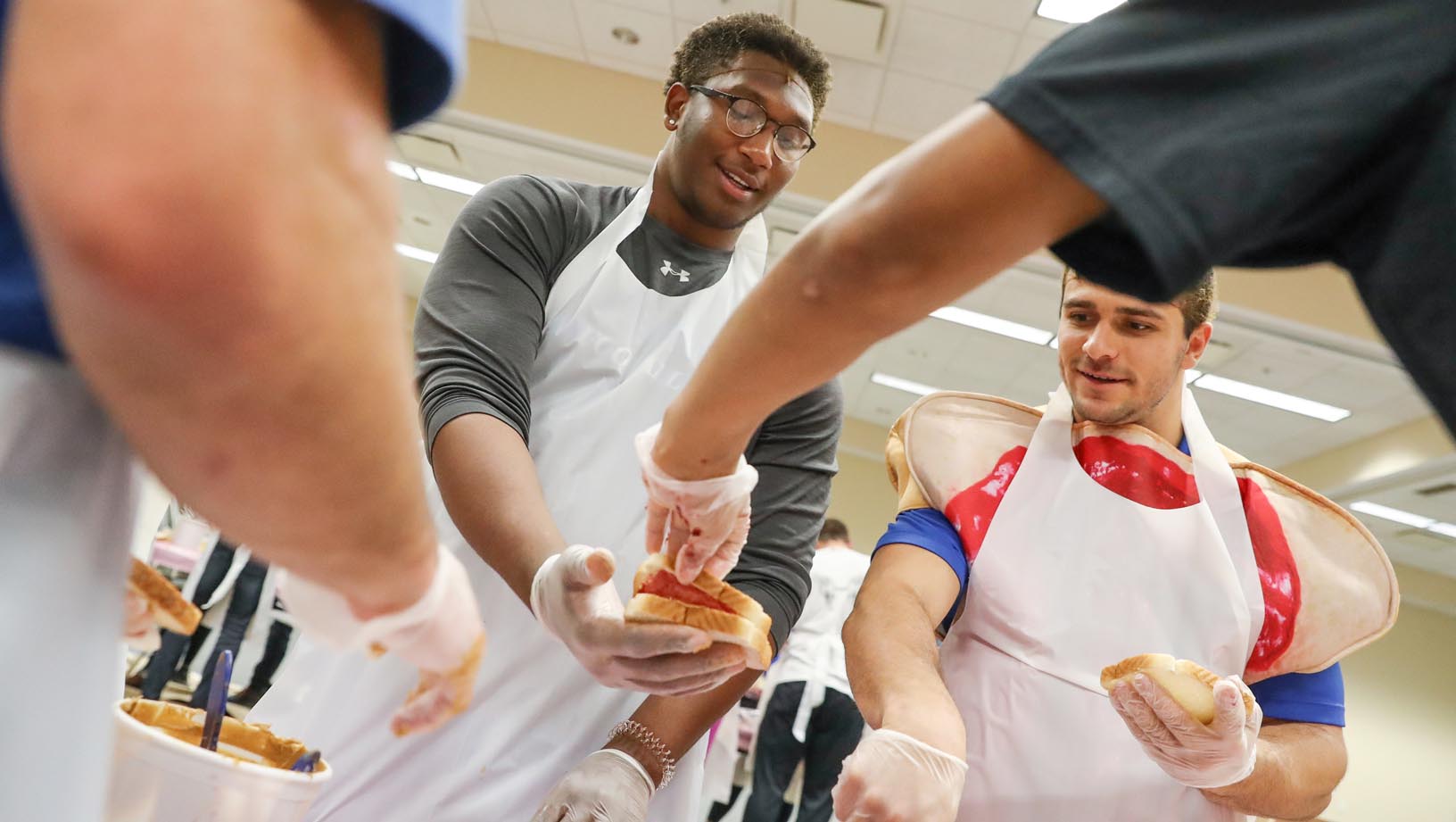 UNK football players Dakarai Monegain-Box, left, and Luke Quinn work with other student-athletes Tuesday during a peanut butter and jelly sandwich drive on campus. UNK Athletics partnered with Sodexo to make and distribute nearly 3,500 sandwiches. (Photos by Corbey R. Dorsey, UNK Communications)