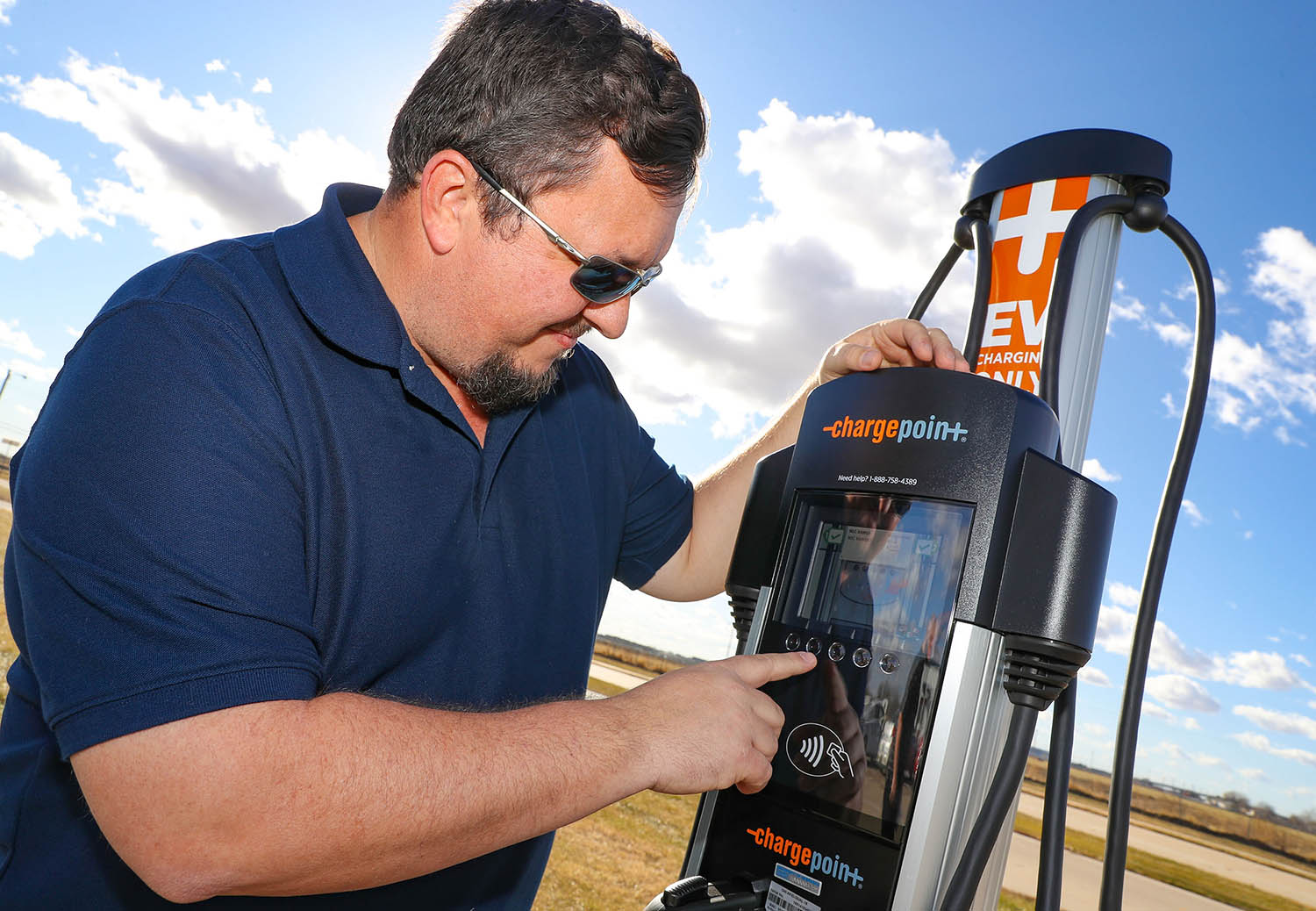 Consumer safety manager Marshall Barth demonstrates the electric vehicle charging station recently installed at the Nebraska Safety Center’s driving range. The charging station is available for public use.