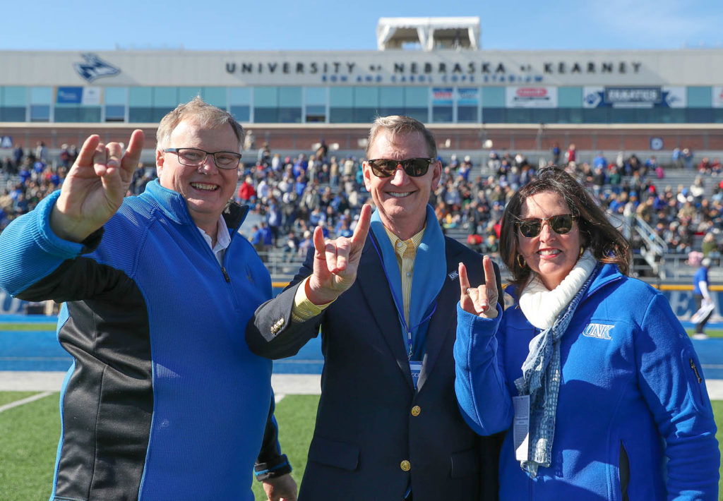 UNK Chancellor Doug Kristensen, left, is pictured with Ted and Lynda Carter during a home football game.
