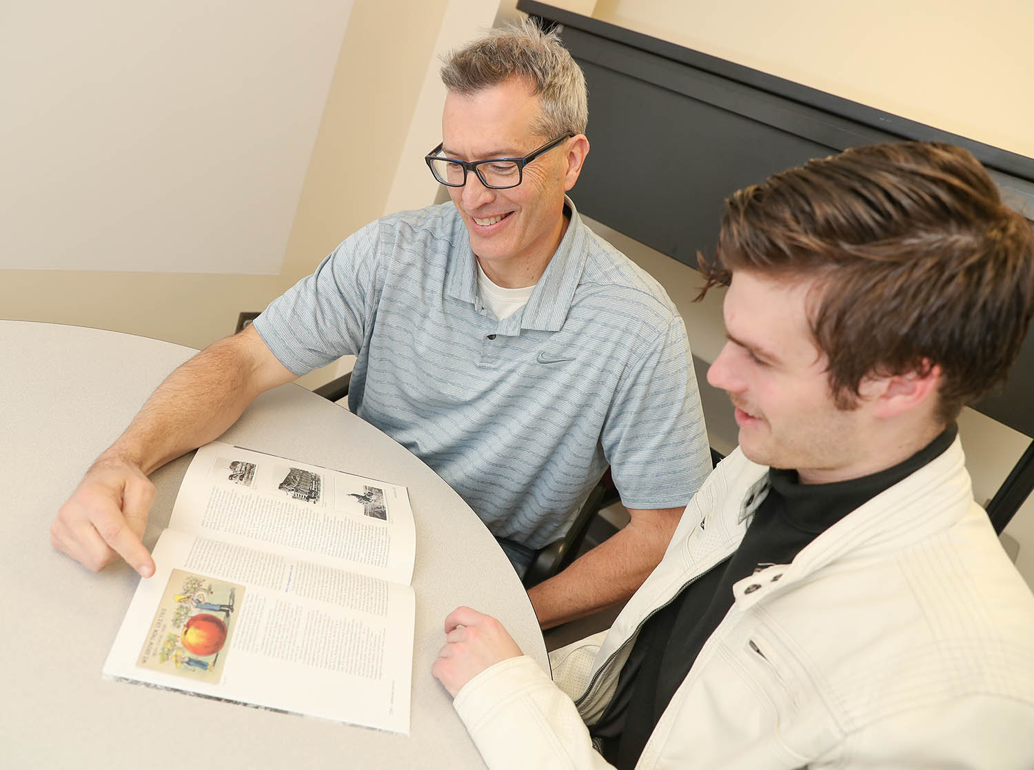 UNK geography professor Jason Combs, left, and his son Tate, a junior at UNK, worked together on a research project studying Nebraska’s “exaggeration postcards.” Their project is featured in the Winter 2019 edition of Nebraska History Magazine. (Photo by Corbey R. Dorsey, UNK Communications)
