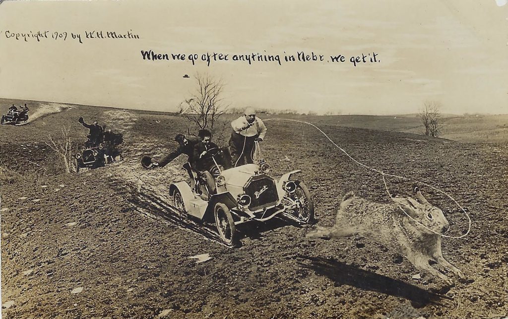 An “exaggeration postcard” from 1909 is altered to make a rabbit appear as large as the vintage Buick that's chasing it down.