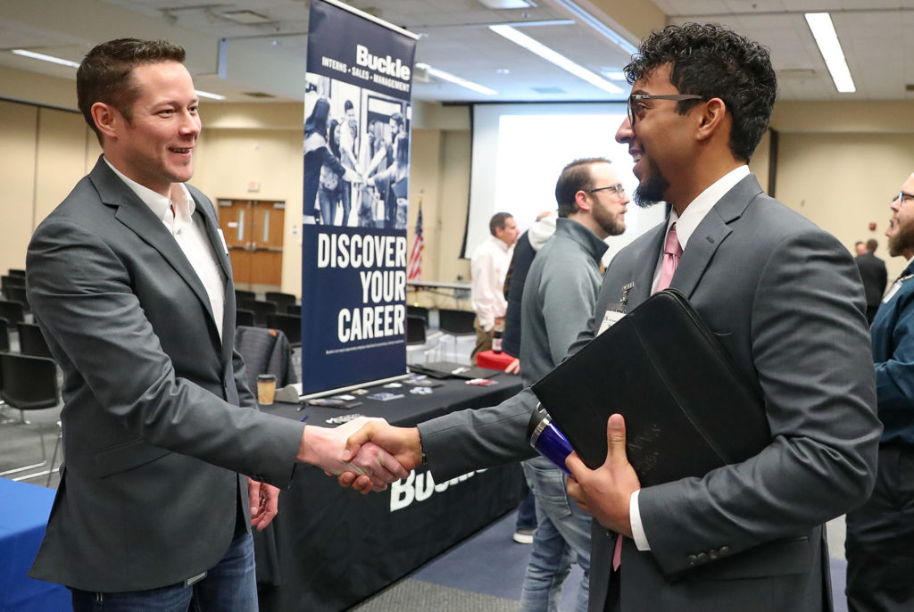 UNK senior Thomas Russell, right, introduces himself to JR Rother, director of information systems for Grand Island-based Bosselman Enterprises, during Thursday’s career event hosted by UNK’s Cyber Systems Department.