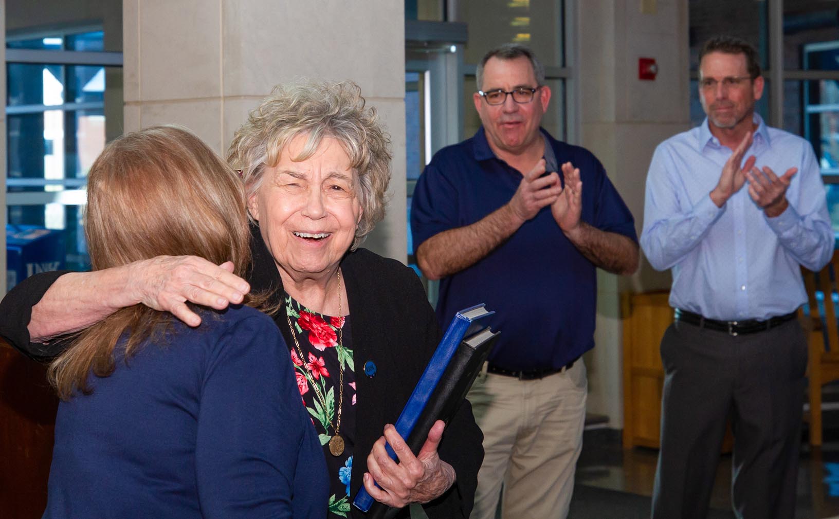 Patricia Hoehner, second from left, a professor of educational administration at UNK, hugs interim College of Education Dean Grace Mims during Friday’s dedication of the Hoehner Family Conference Room. (Photos by Chase Harmon, UNK Communications)