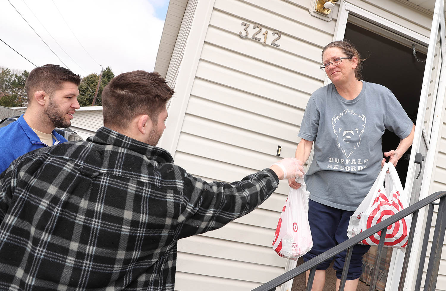 UNK wrestlers Anthony Mancini, left, and Matt Malcom deliver meals to Paula Cowen on Tuesday while volunteering for Hot Meals USA. (Photos by Corbey R. Dorsey, UNK Communications)