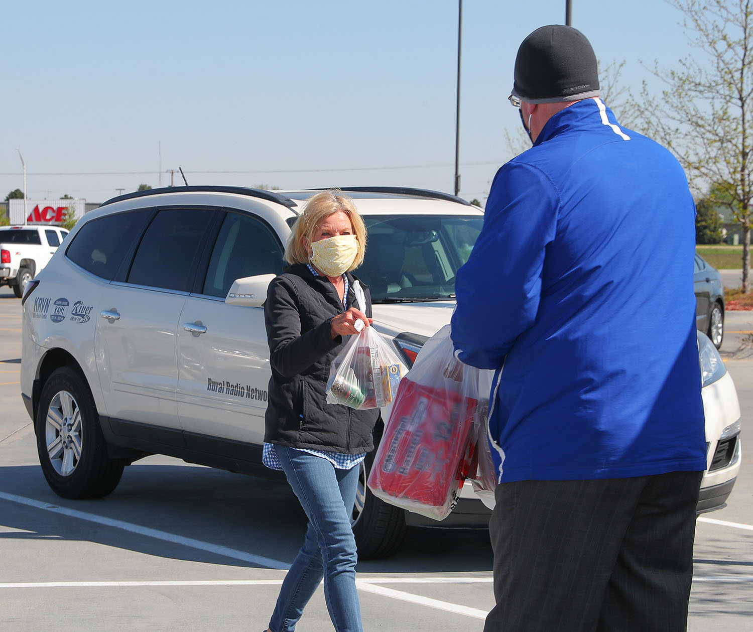 A community member brings her donation to Brandon Benitz of KRVN Radio during Friday’s “Lopers Love to Help” food drive at Hy-Vee in Kearney. Organized by UNK Athletics, the event supported the Big Blue Cupboard food pantry on campus.