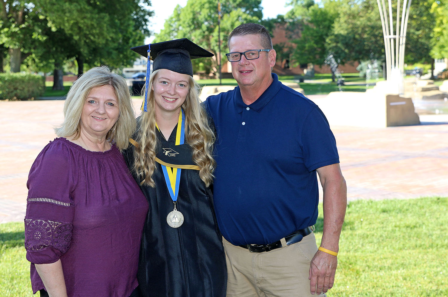 UNK graduate Madison Clausen of Norfolk poses for a photo with her parents Penny and Mark before Friday’s commencement ceremony. Clausen earned a bachelor’s degree in communication disorders and she’ll pursue a master’s in speech-language pathology at UNK this fall.