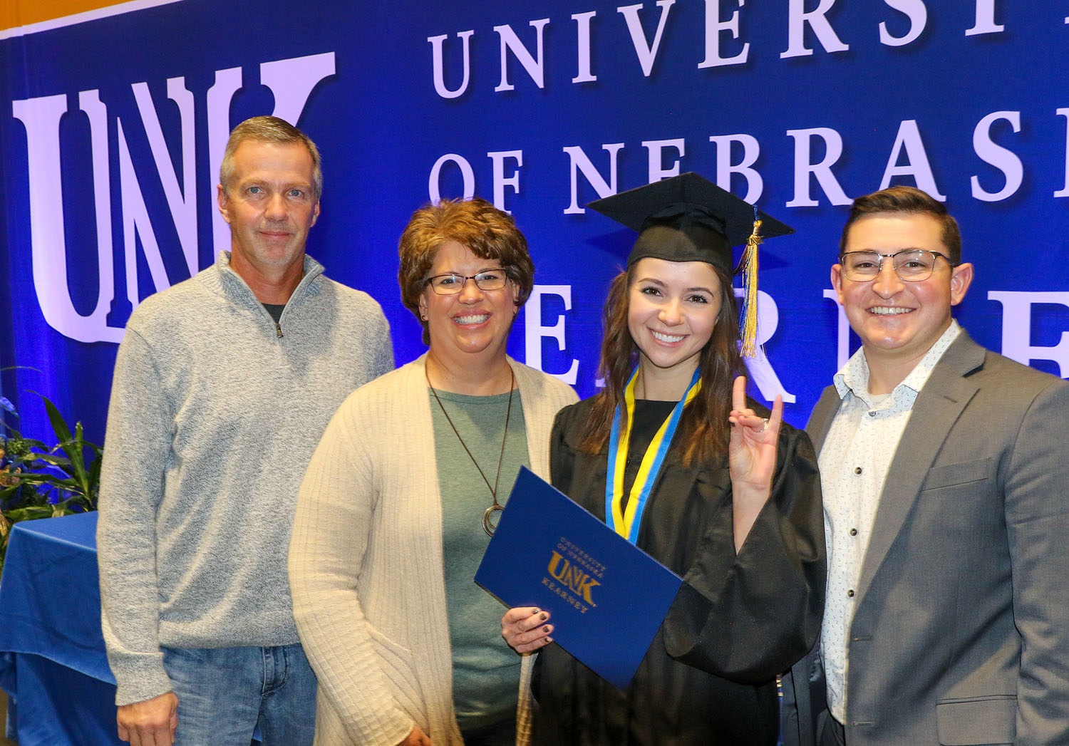 UNK graduate Kaitlyn Becher of Leigh poses for a photo with her parents Bill and Jill and fiancé Jon Venzor following Friday’s commencement ceremony. “It’s really exciting to see her take the next step in her life,” Jill Becher said of her daughter. (Photos by Todd Gottula, UNK Communications)