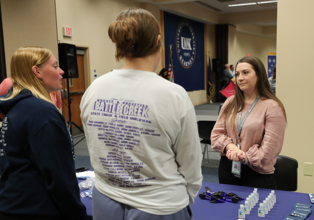 Sarah Barfknecht, a UNK senior and human resources intern with Kearney Regional Medical Center, right, discusses the health care field with high schoolers attending Wednesday’s Health Careers Fair.
