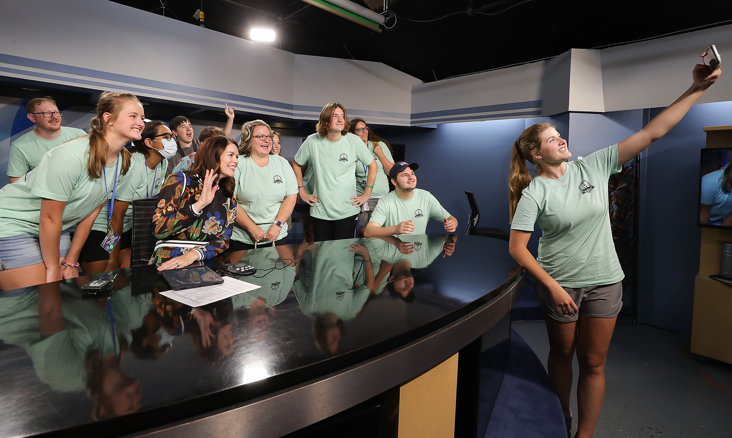 Grace McDonald, right, takes a photo with NTV news anchor Colleen Williams and high school students participating in the Digital Expressions Media Camp. McDonald served as a counselor for the weeklong summer camp.