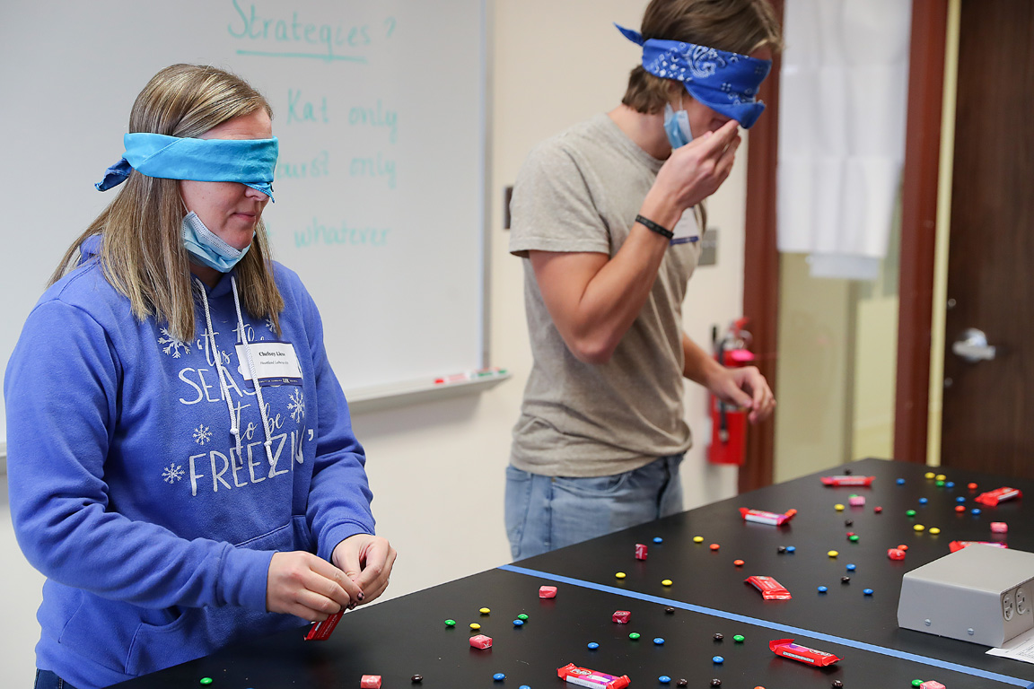 Heartland Lutheran High School Principal Chelsey Liess, left, and Hershey High School student Cruz Brooks participate in a foraging exercise during the UNK Science Day wildlife biology session.