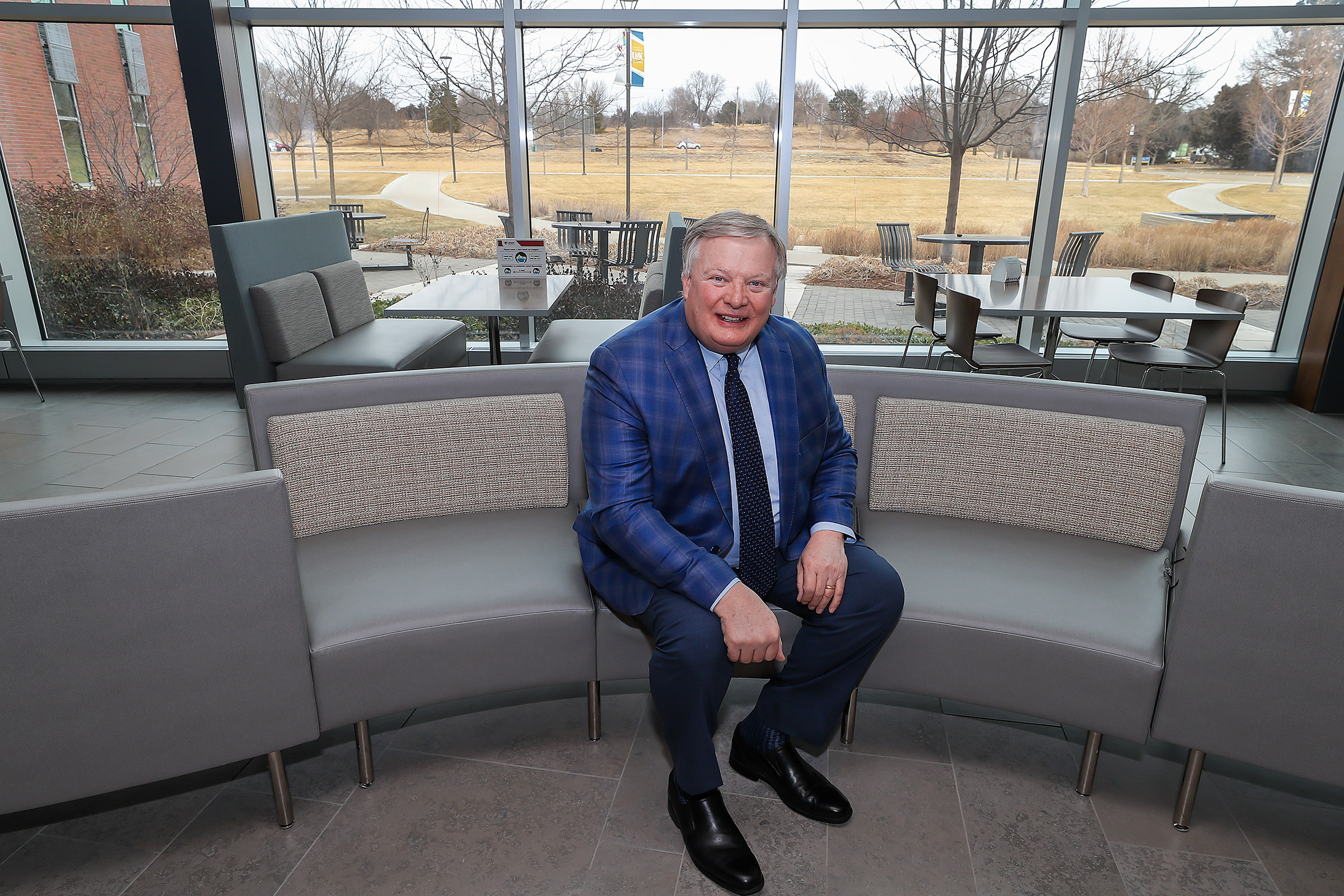 UNK Chancellor Doug Kristensen is pictured inside the Health Science Education Complex on campus, with the site of the proposed Rural Health Education Building in the background. (Photo by Erika Pritchard, UNK Communications)