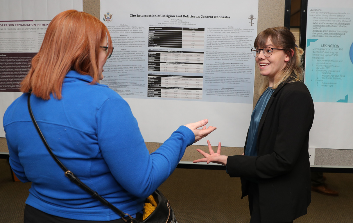 UNK senior Haley Mazour, right, discusses her research with assistant psychology professor Katherine Moen during Thursday’s Research Day celebration.