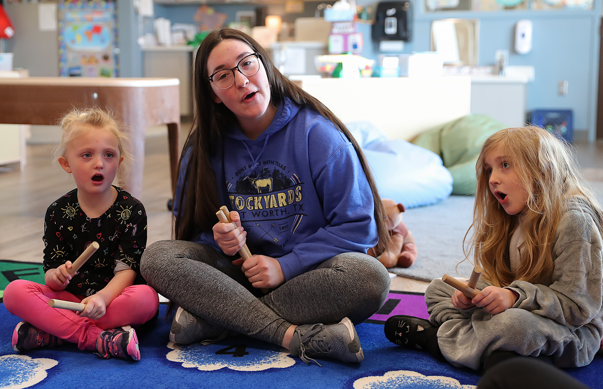 UNK freshman Kelly Richards leads a singalong Thursday at the Plambeck Early Childhood Education Center.