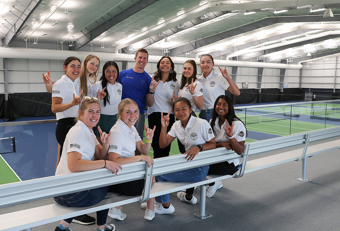 Members of the UNK women’s tennis team pose for a photo inside the new Ernest Grundy Tennis Center. The players represent three different U.S. states and six different countries.