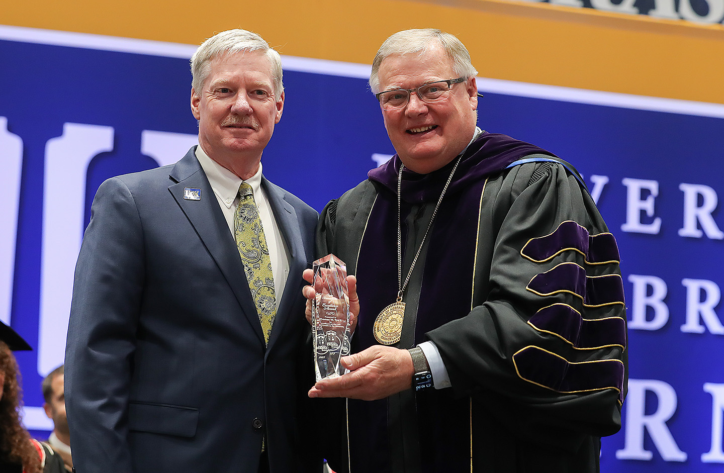 Tom Tye, left, receives the Ron and Carol Cope Cornerstone of Excellence Award from UNK Chancellor Doug Kristensen during Friday’s spring commencement ceremony. (Photos by Erika Pritchard, UNK Communications)