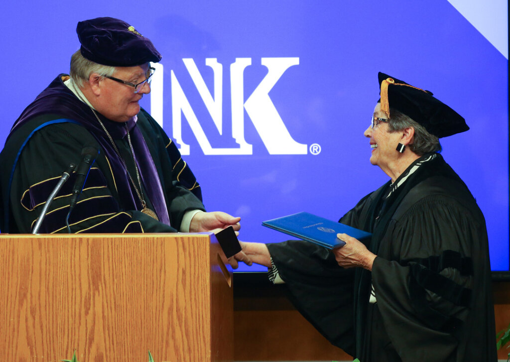 UNK Chancellor Doug Kristensen awards an honorary doctorate to Eileen Carpenter during a ceremony Friday inside the Nebraskan Student Union.