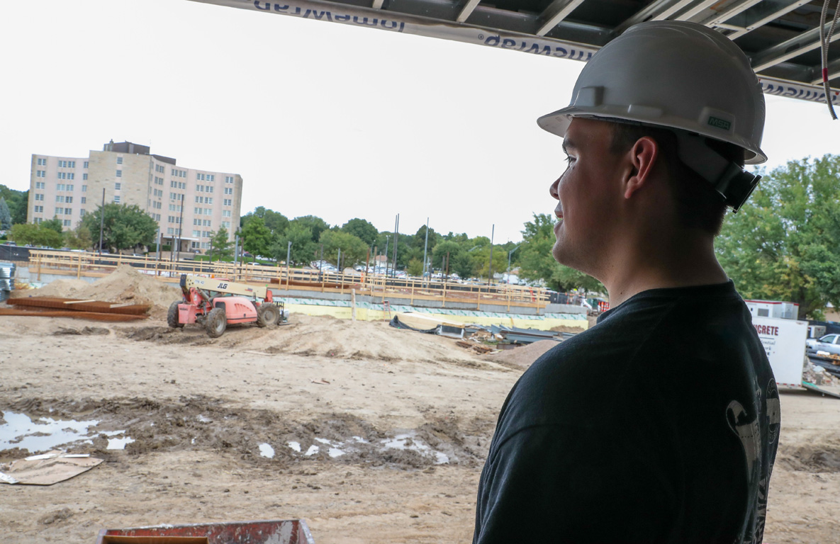 From nearby Martin Hall, Pi Kappa Alpha member Zeke Abeyta looks at the progress on a new residence hall under construction on UNK’s east campus. Both buildings will serve fraternities and sororities. (Photos by Erika Pritchard, UNK Communications)
