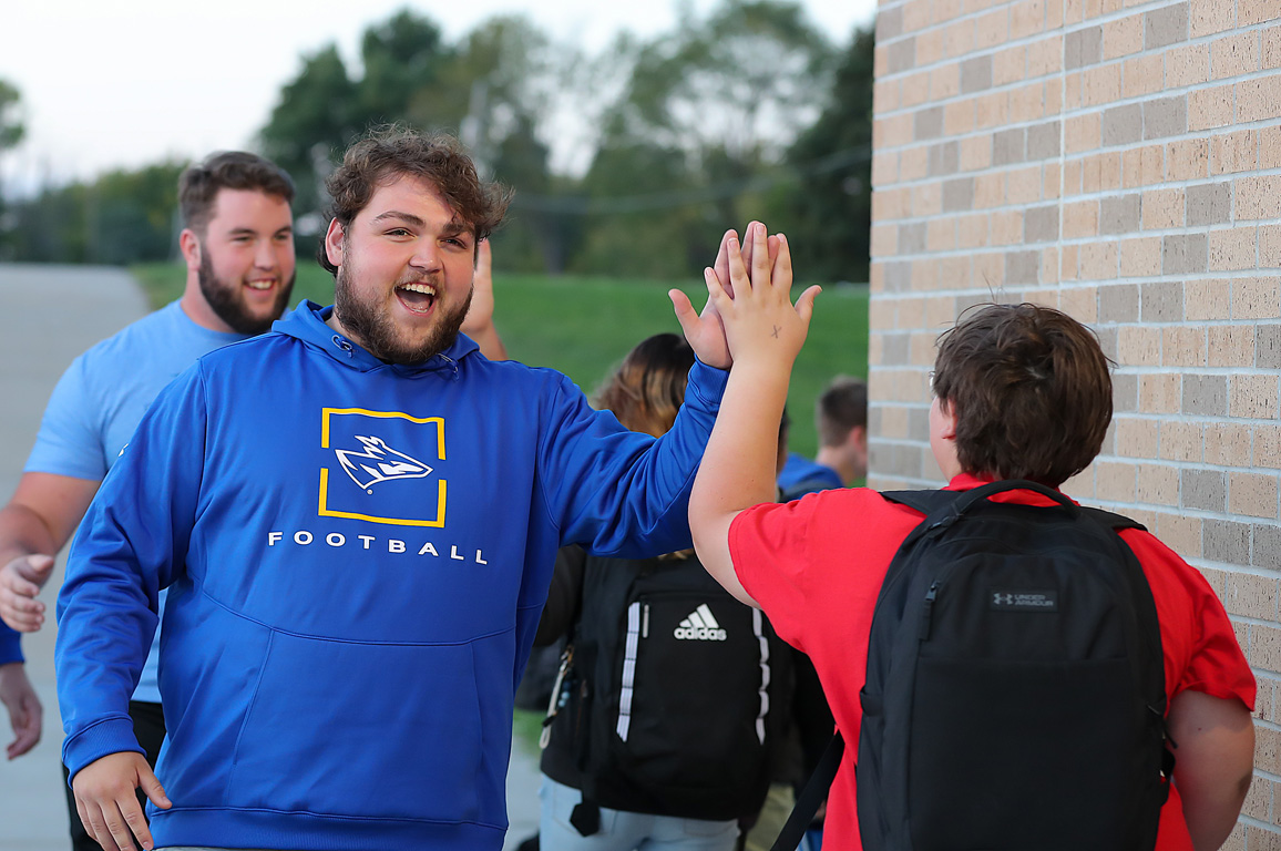 UNK football player Drake Sherman greets a Horizon Middle School student Friday morning. Loper student-athletes visit local elementary and middle schools each week for High Five Friday. (Photos by Erika Pritchard, UNK Communications)