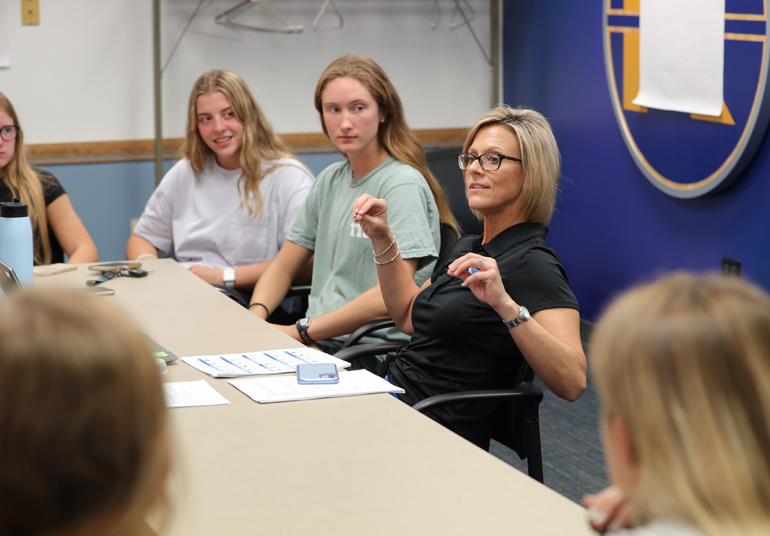 Kifani Hoff, associate director of counseling at UNK, discusses mental health with members of the women's basketball team during a recent meeting at the Health and Sports Center.