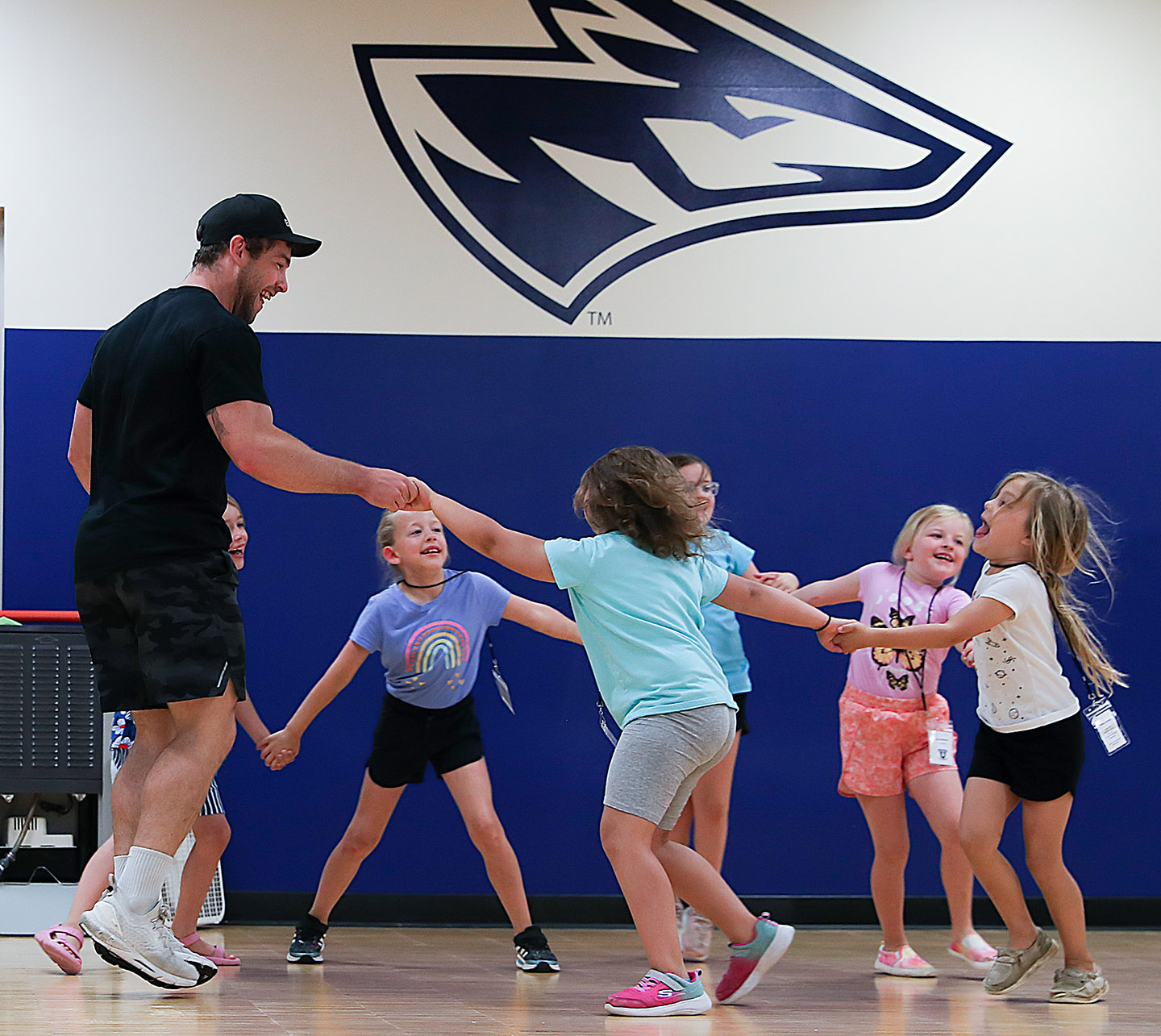 Bryant Isaacs works with children last summer during a PAWS University cheer camp at UNK. (Photo by Erika Pritchard, UNK Communications)