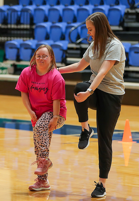 UNK junior Kali Herbolsheimer, right, and Special Olympics athlete Marti Cramer warm up Wednesday evening during a unified basketball event at the Health and Sports Center.
