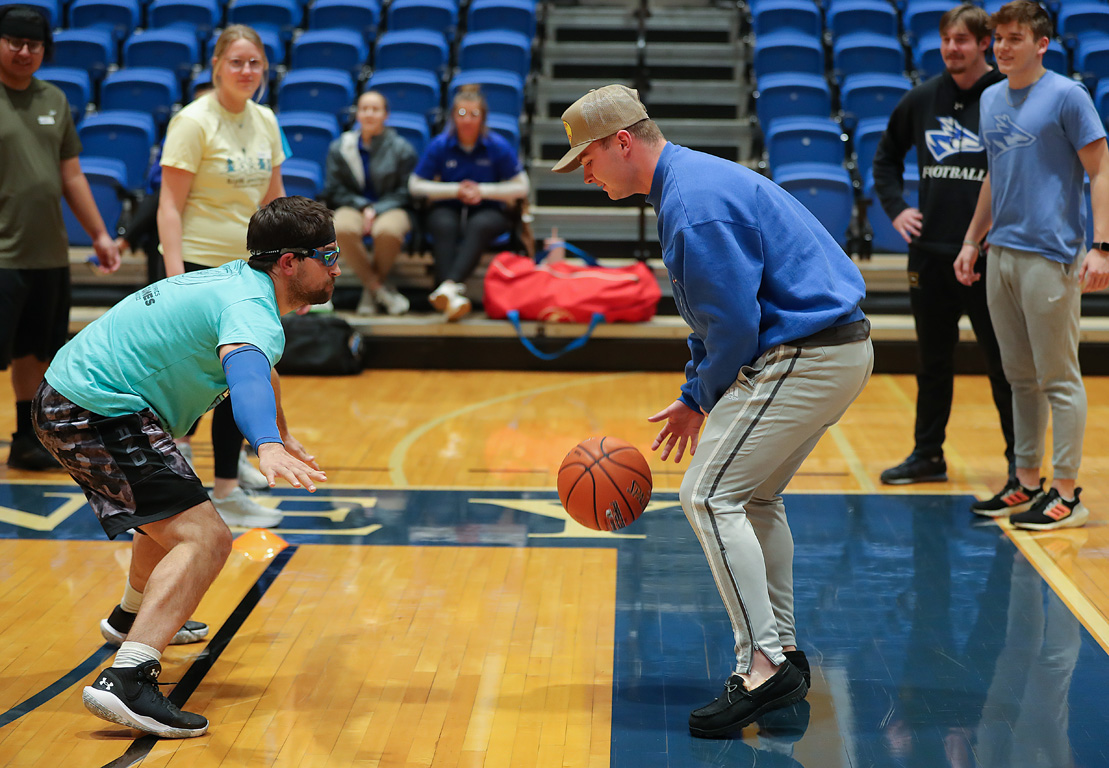 Special Olympics athlete Craig Schutt, left, participates in a defensive drill Wednesday evening during a unified basketball event at UNK’s Health and Sports Center.