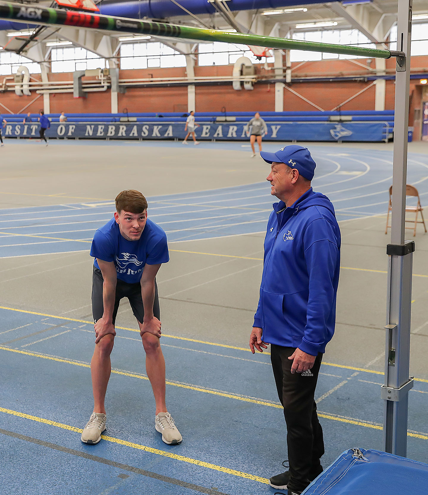 UNK senior Brayden Sorensen and assistant track and field coach Lonny Polacek work together during a recent practice at Cushing Coliseum. (Photo by Erika Pritchard, UNK Communications)