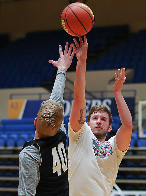 Dylan Simmons, a graduate assistant in UNK Campus Recreation, shoots over his boss, Andrew Winscot, during a recent noon ball game.