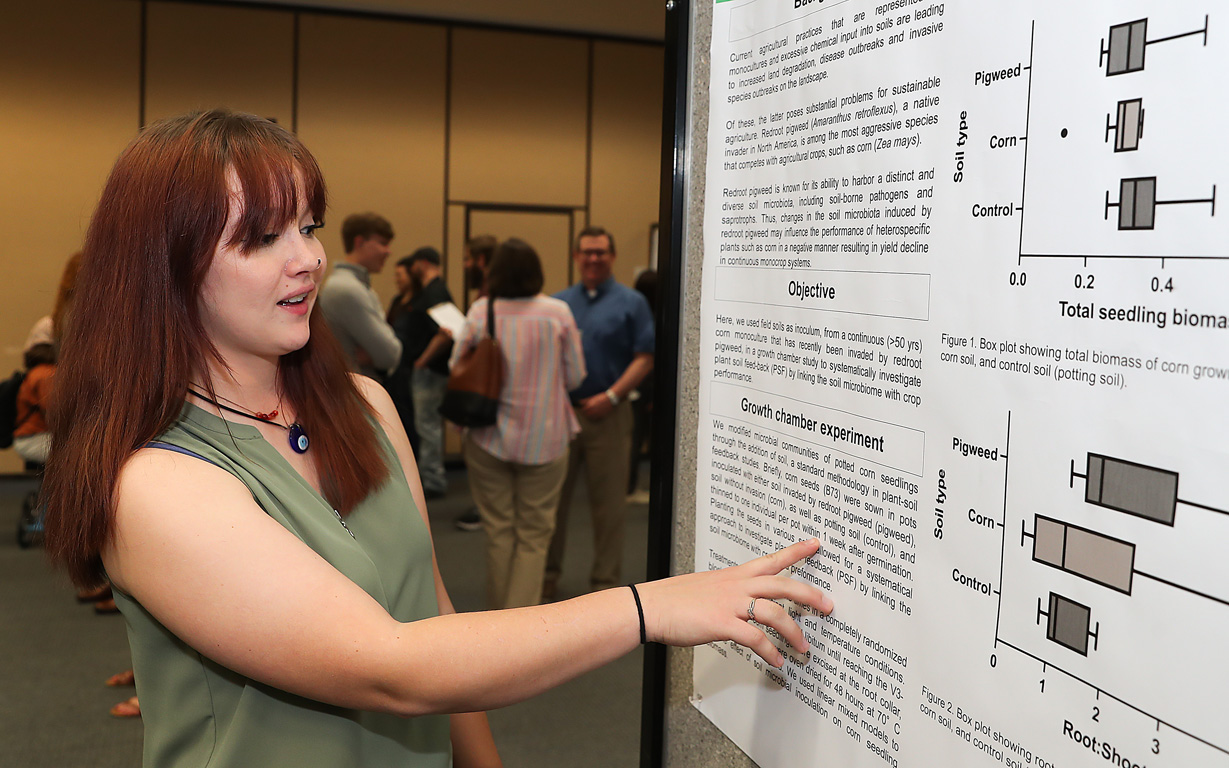 UNK junior Austie Kreikemeier discusses her research project Thursday during the annual Research Day event on campus. The wildlife biology major is studying redroot pigweed and its impact on corn production. (Photos by Erika Pritchard, UNK Communications)